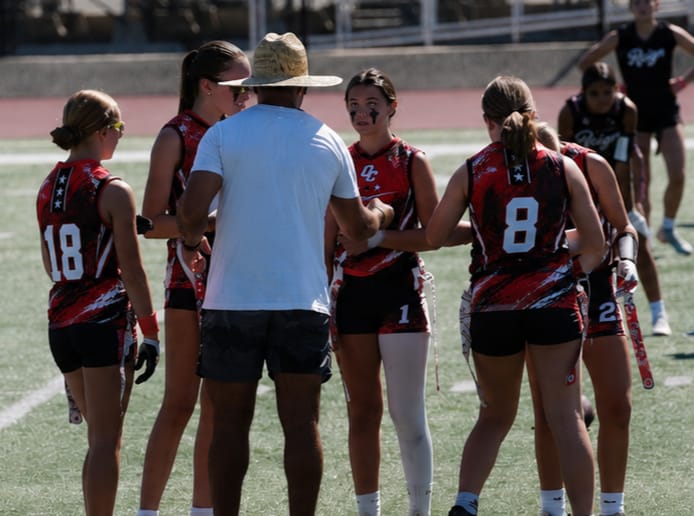 OC HAVOC coach huddling with girls flag football players during a game